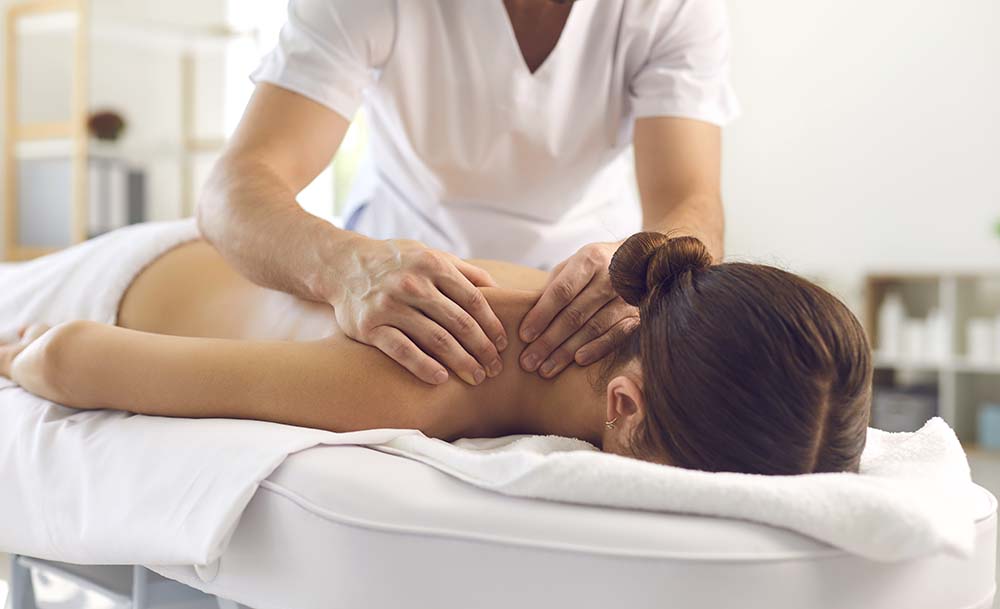 Persona fent un massatge a l'espatlla d'una clienta